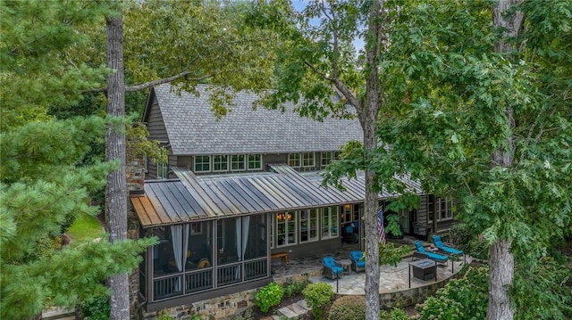 202 Passion Flower Way, Sunset, SC 29685 - back of property featuring a sunroom, a patio, a standing seam roof, an outdoor fire pit, and a metal roof