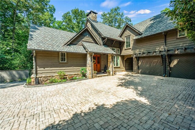 202 Passion Flower Way, Sunset, SC 29685 - view of front of house with a chimney, stone siding, driveway, and a garage