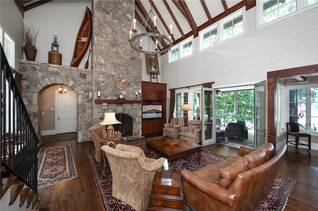 living room with an inviting chandelier, a fireplace, dark hardwood / wood-style flooring, and high vaulted ceiling