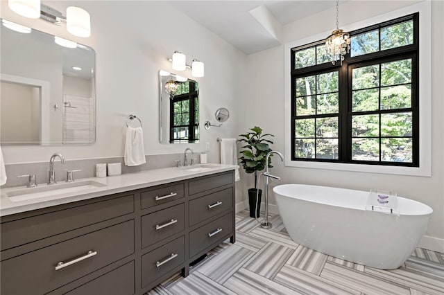 bathroom featuring a tub to relax in, plenty of natural light, and vanity