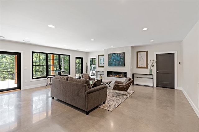 living room featuring a large fireplace and a healthy amount of sunlight