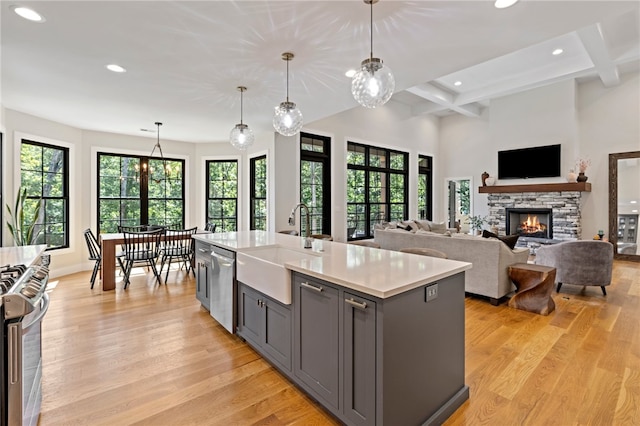 kitchen featuring a wealth of natural light, an island with sink, and pendant lighting