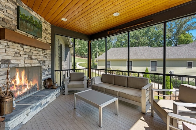 unfurnished sunroom with wooden ceiling and an outdoor stone fireplace