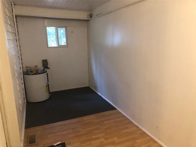 basement with gas water heater and light hardwood / wood-style floors