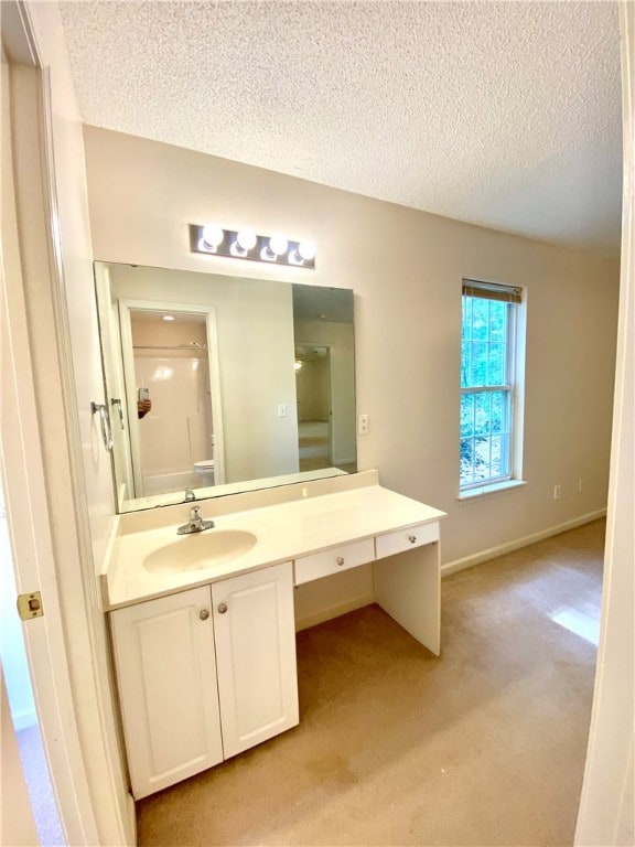 bathroom featuring vanity, a textured ceiling, and walk in shower