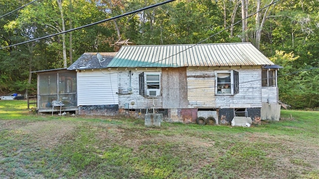 view of side of property featuring cooling unit and a yard