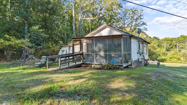 view of side of property with a yard and a sunroom