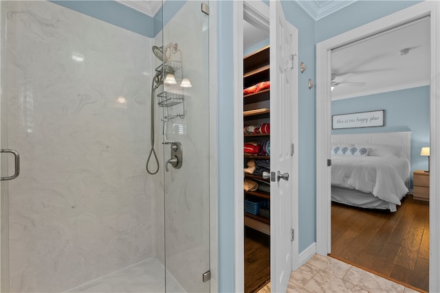 bathroom featuring crown molding, hardwood / wood-style flooring, a shower with shower door, and ceiling fan