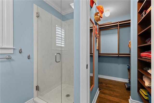 bathroom with walk in shower, hardwood / wood-style flooring, and ornamental molding