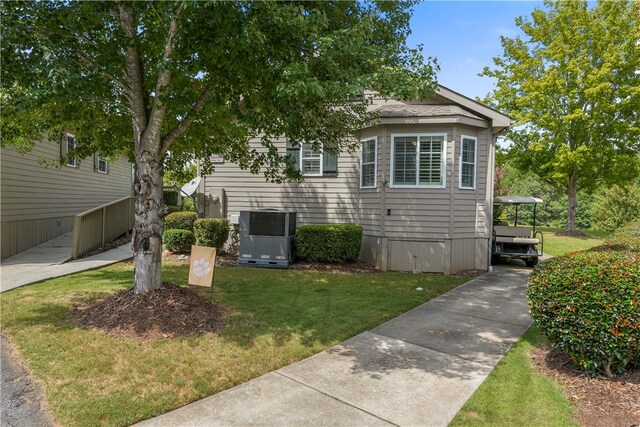 view of front of house with a front yard and central air condition unit