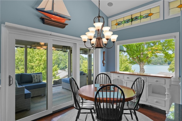 dining area with a notable chandelier, dark hardwood / wood-style flooring, plenty of natural light, and a water view