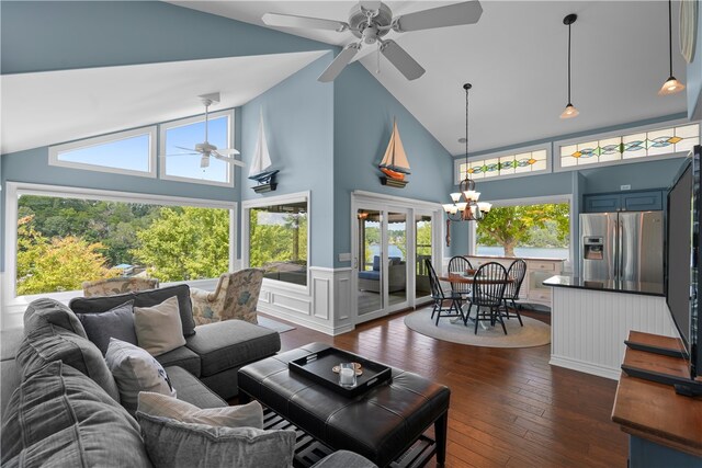 living room with ceiling fan with notable chandelier, high vaulted ceiling, and dark hardwood / wood-style floors