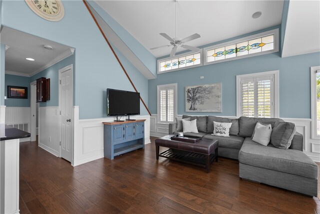 living room with dark hardwood / wood-style flooring, a wealth of natural light, a high ceiling, and ceiling fan