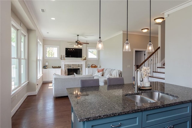 kitchen featuring decorative light fixtures, sink, blue cabinetry, and a wealth of natural light