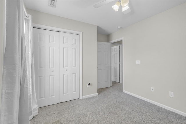 unfurnished bedroom with ceiling fan, light colored carpet, and a closet