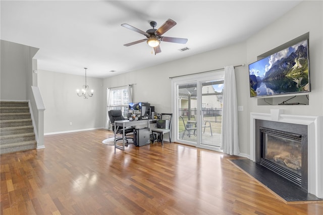 office space featuring ceiling fan with notable chandelier, hardwood / wood-style flooring, and a healthy amount of sunlight