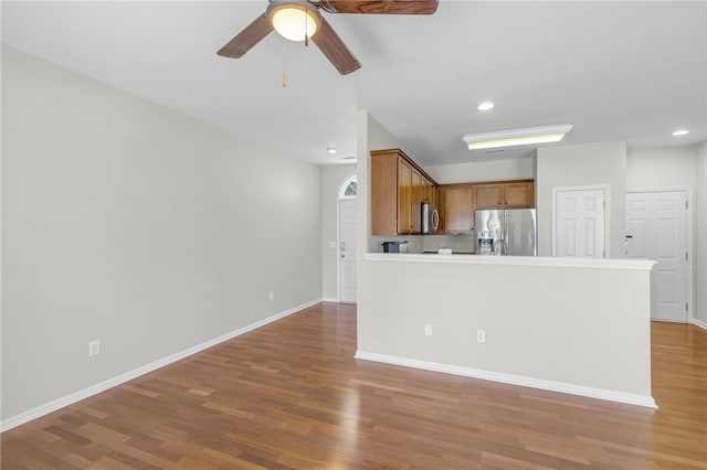 kitchen featuring ceiling fan, hardwood / wood-style flooring, and stainless steel appliances