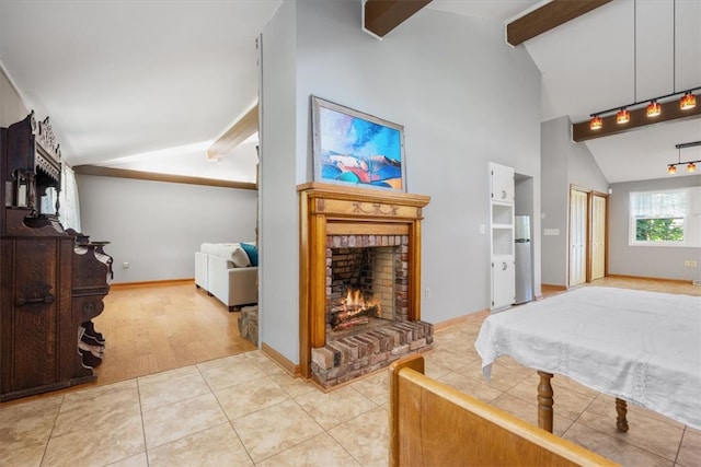 bedroom featuring vaulted ceiling with beams, stainless steel refrigerator, light hardwood / wood-style flooring, and a brick fireplace