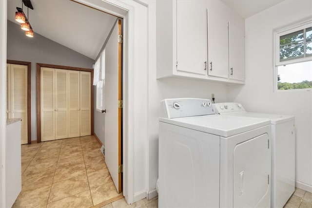 laundry area with light tile patterned floors, independent washer and dryer, and cabinets