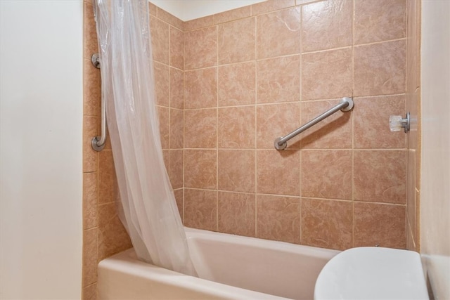 bathroom with shower / bath combo with shower curtain and toilet