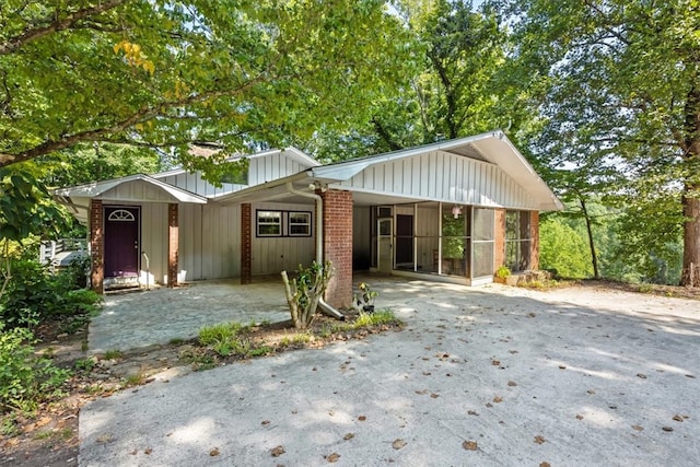 view of front of house featuring a carport and a sunroom