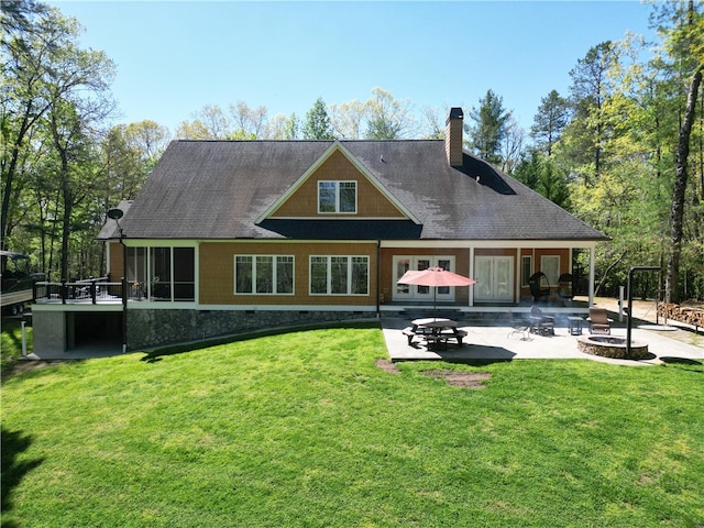 rear view of property featuring a lawn, a patio area, and a fire pit