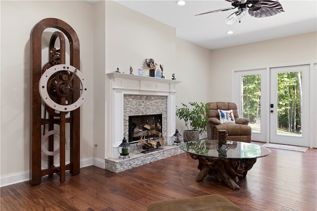 living room featuring ceiling fan, a fireplace, dark wood-type flooring, and french doors