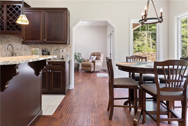 dining area with dark hardwood / wood-style flooring and a notable chandelier