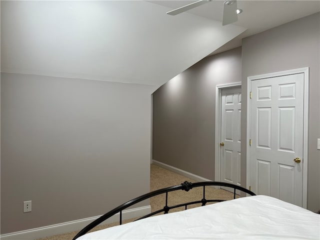 unfurnished bedroom featuring light carpet, ceiling fan, and vaulted ceiling