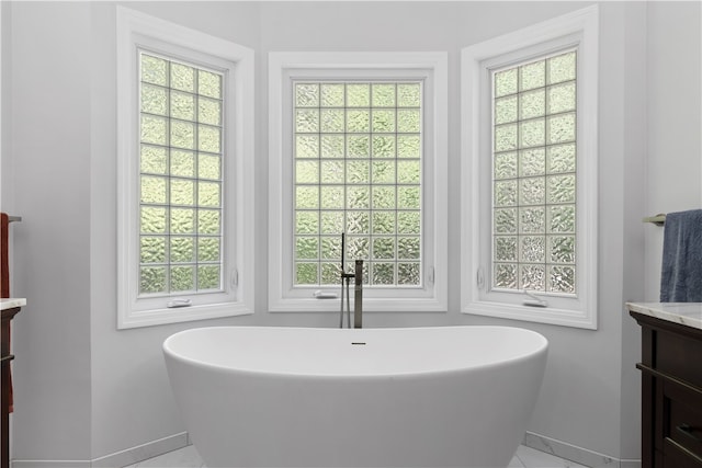 bathroom with a washtub, plenty of natural light, and vanity