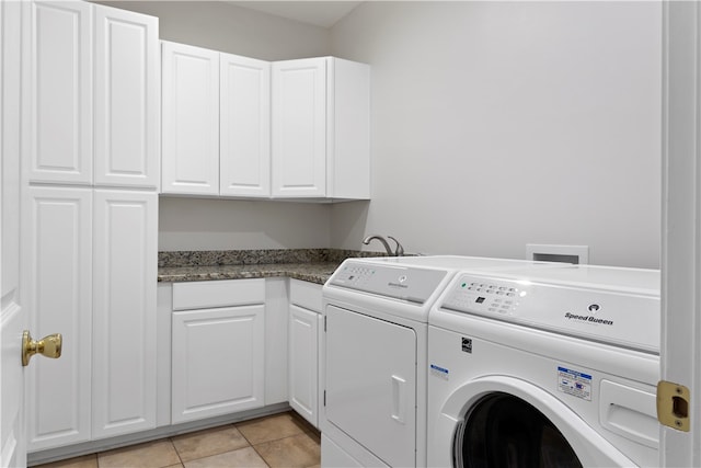 laundry room featuring light tile patterned flooring, cabinets, and separate washer and dryer