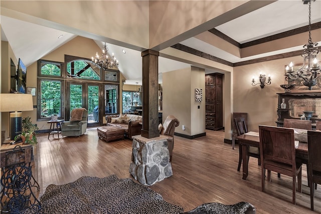 living room with hardwood / wood-style floors, ornate columns, high vaulted ceiling, and a chandelier