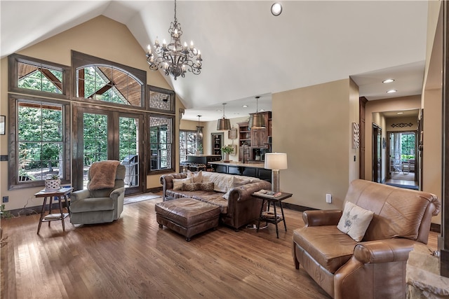 living room featuring high vaulted ceiling, wood-type flooring, and a notable chandelier