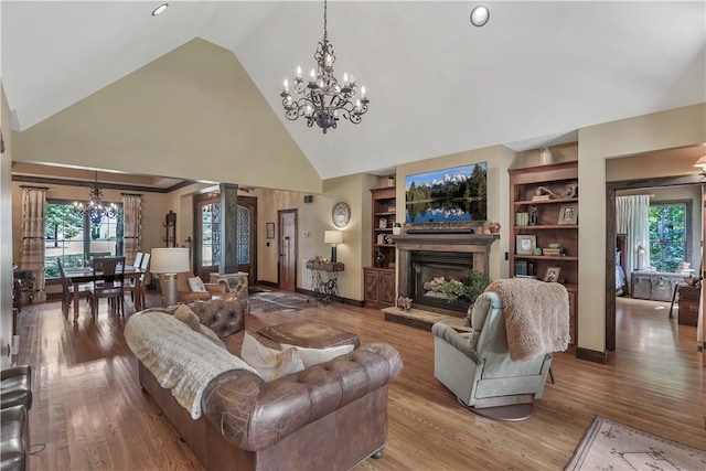 living room with built in shelves, hardwood / wood-style flooring, and a wealth of natural light