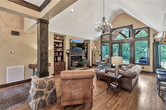 living room featuring ornate columns, hardwood / wood-style floors, a chandelier, and high vaulted ceiling