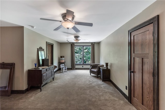 sitting room with ceiling fan and carpet flooring