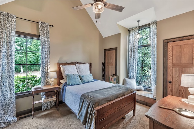 carpeted bedroom with ceiling fan with notable chandelier and high vaulted ceiling