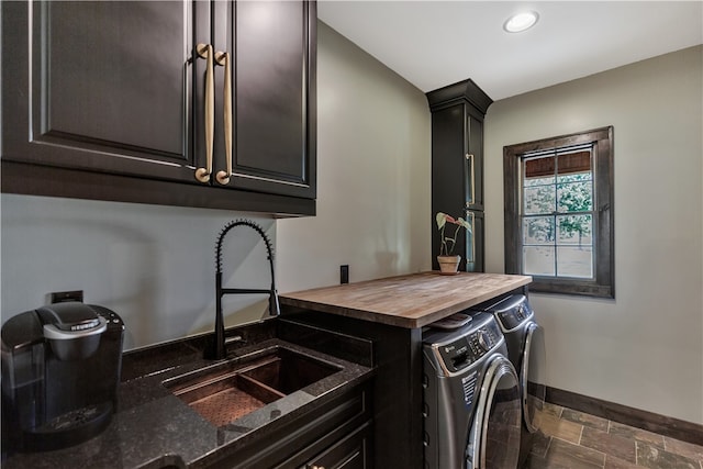 laundry area featuring separate washer and dryer, sink, and cabinets