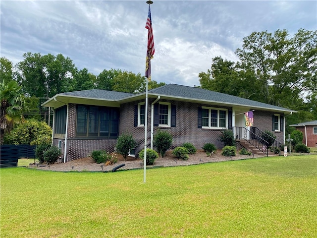 single story home featuring a sunroom and a front yard