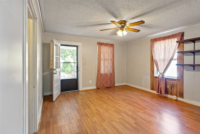 unfurnished room featuring a textured ceiling, crown molding, ceiling fan, and light hardwood / wood-style flooring