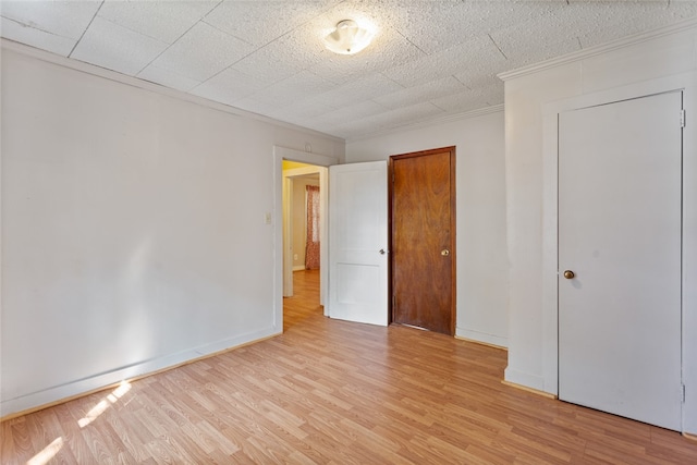 unfurnished bedroom featuring light hardwood / wood-style flooring and crown molding