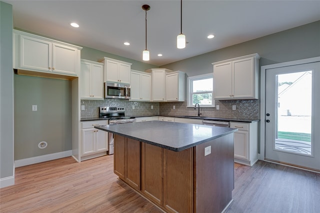 kitchen featuring light hardwood / wood-style flooring, stainless steel appliances, white cabinetry, and a kitchen island