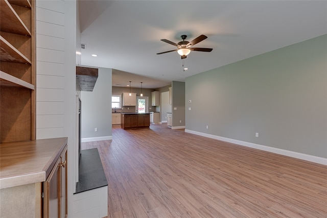 unfurnished living room with ceiling fan and hardwood / wood-style flooring