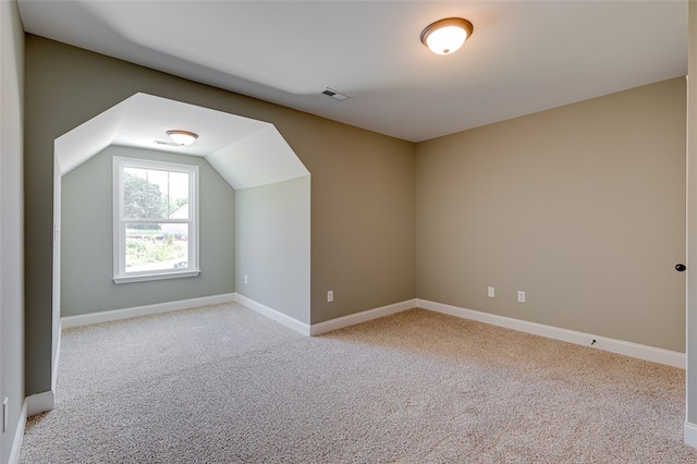 bonus room featuring lofted ceiling and light colored carpet