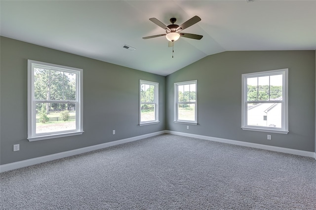 carpeted empty room with vaulted ceiling, ceiling fan, and a healthy amount of sunlight