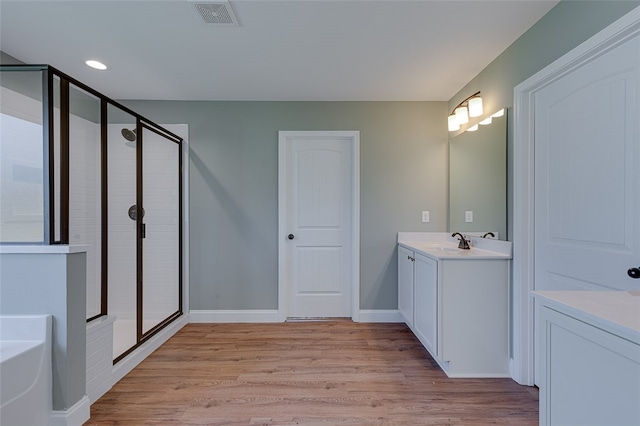 bathroom featuring shower with separate bathtub, vanity, and wood-type flooring