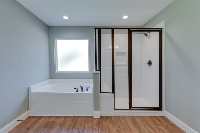 bathroom featuring independent shower and bath and hardwood / wood-style flooring