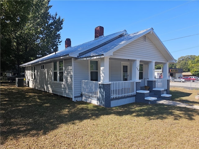 view of front of home with a front lawn, covered porch, and central air condition unit