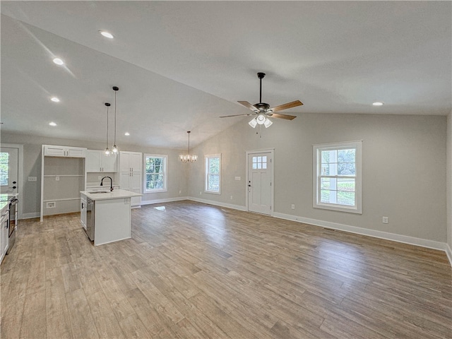 kitchen with white cabinets, lofted ceiling, sink, a center island with sink, and light wood-type flooring