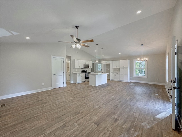 unfurnished living room with lofted ceiling, ceiling fan with notable chandelier, light hardwood / wood-style flooring, and sink